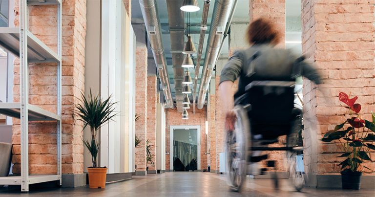 Woman in a wheelchair in a open plan office