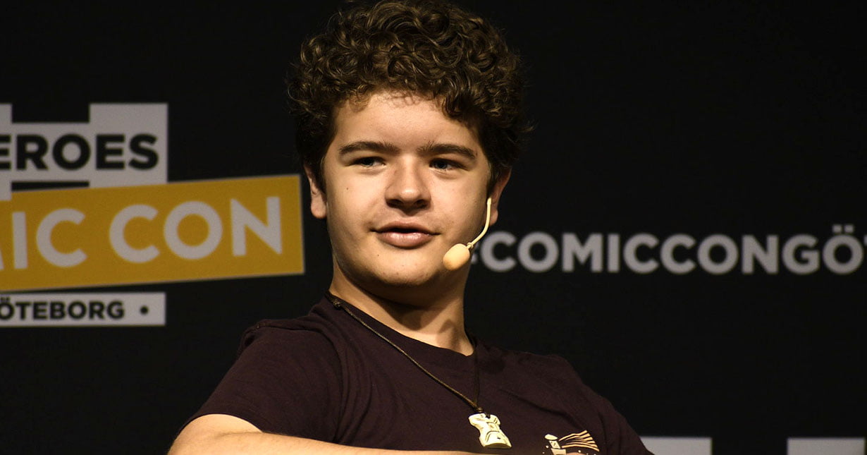 Gaten on a black background with a microphone on his head