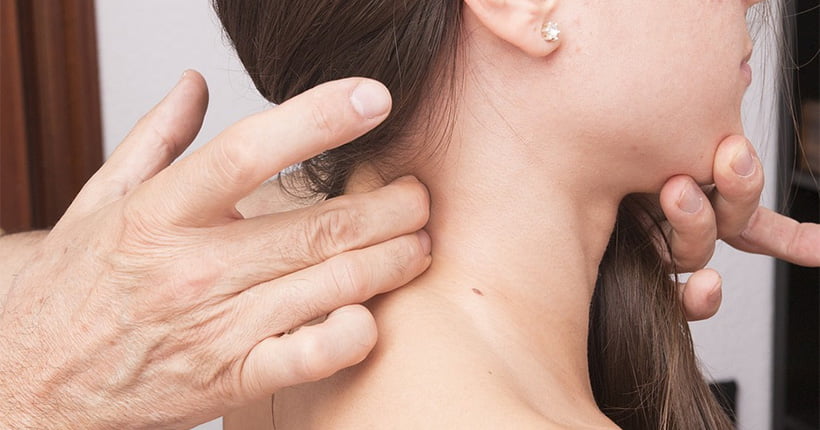 Woman in pain having someone press her neck with their fingers