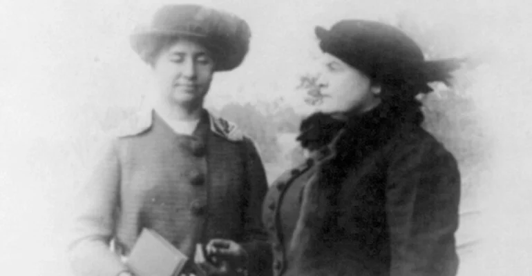 Helen Keller and Anne Sullivan standing outside in warm coats