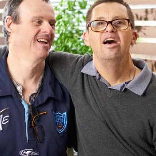 Two men with a disability laughing while at an Aruma disability service