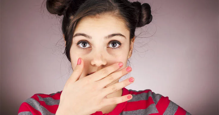 Girl covering her mouth with her hand