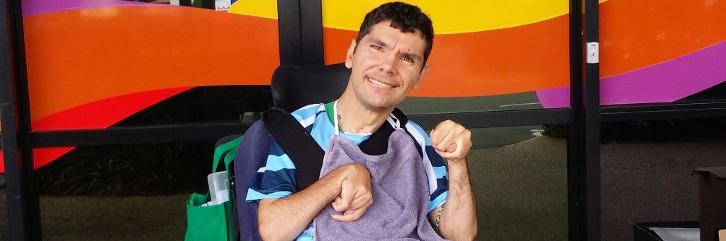 Man with a disability in front of a colourful background