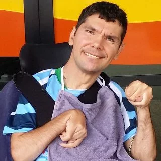 Man with a disability in front of a colourful background