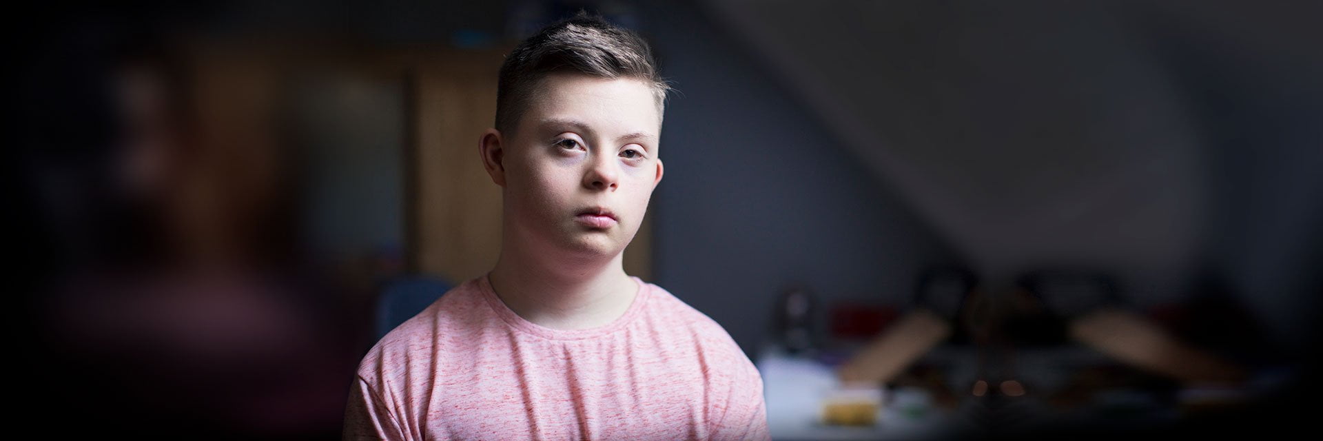 Young man with down syndrome looking at the camera and not smiling
