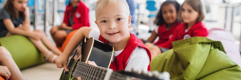 Young boy with a disability playing a guitar