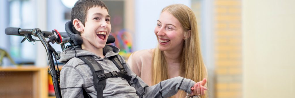 Child with a disability using a wheelchair with a female carer