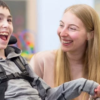 Child with a disability using a wheelchair with a female carer