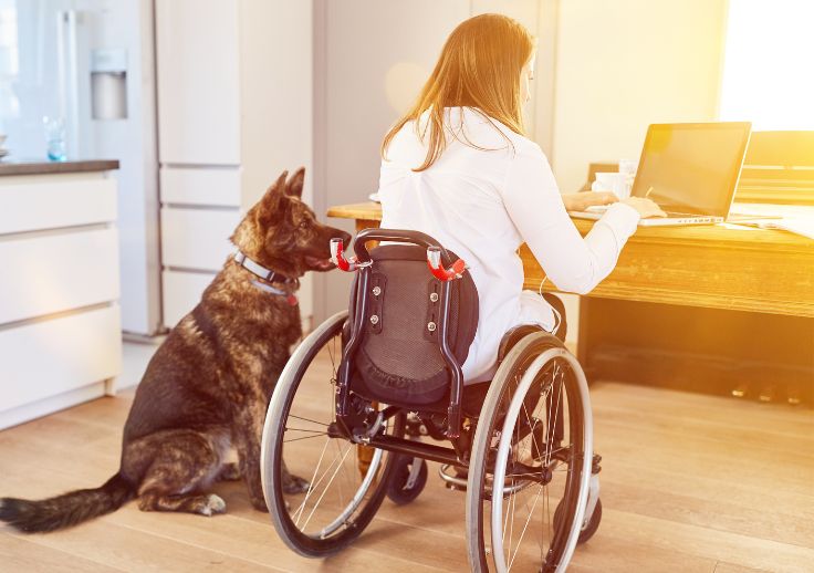 person with disability with a pet dog by her side.
